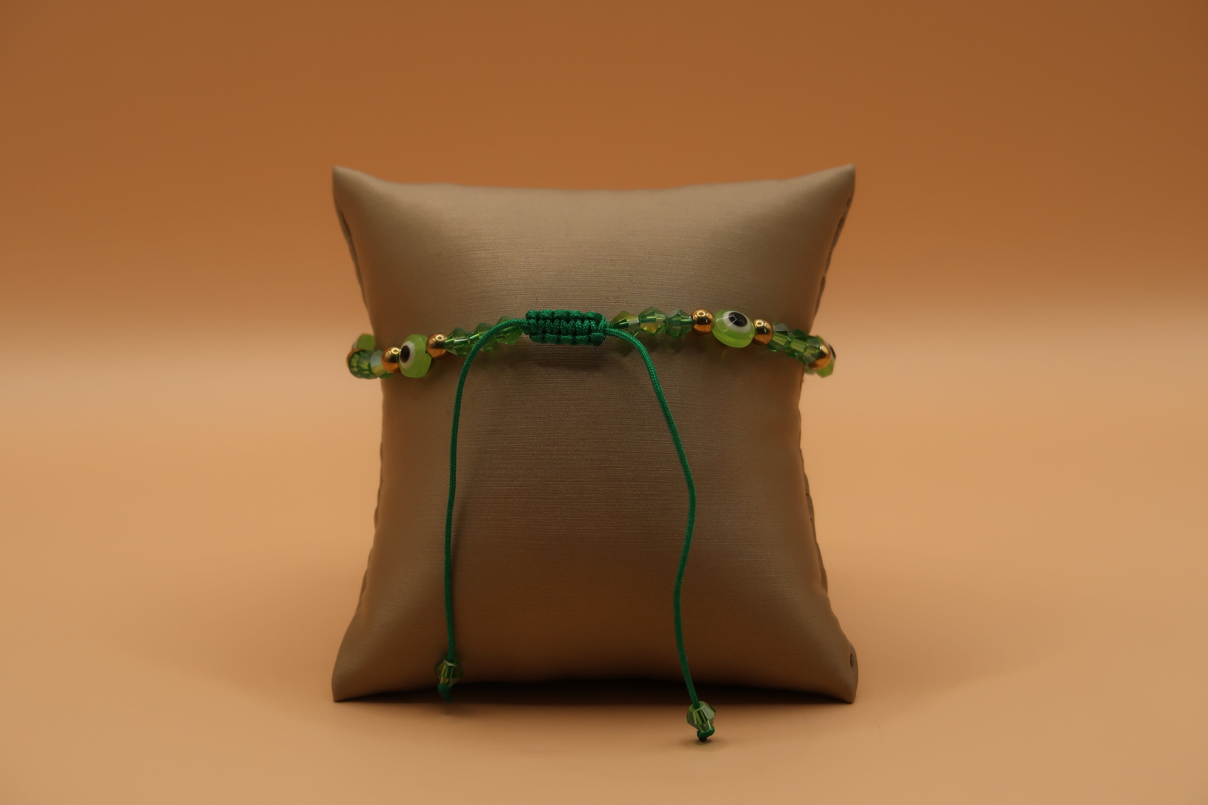 Dangling San Judas lime green evil eye bracelet